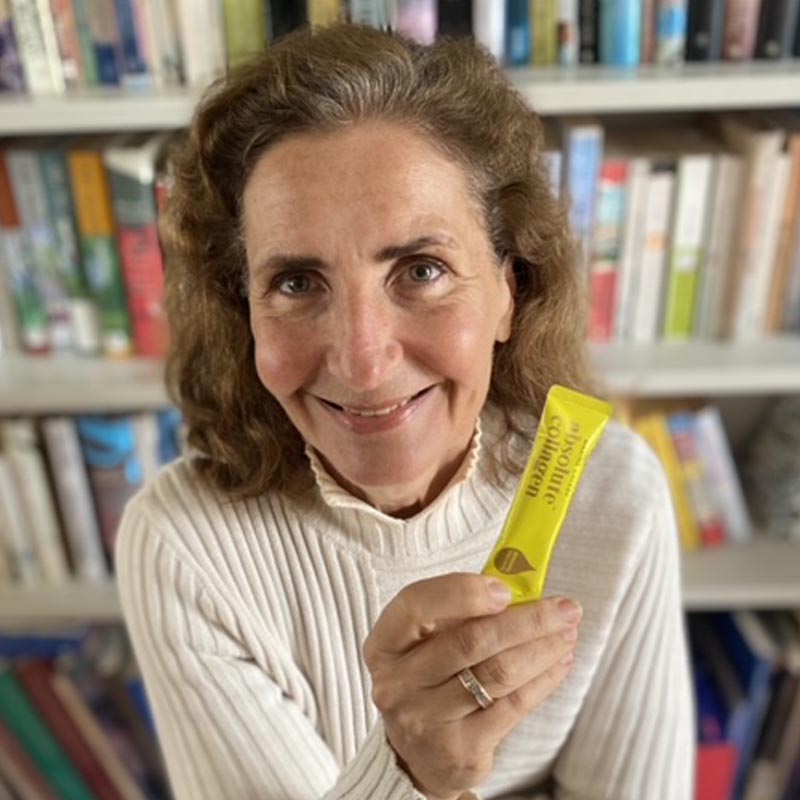 Photo d'Hélène, une Absoluteur souriante tenant un sachet d'élixir de collagène dans sa main